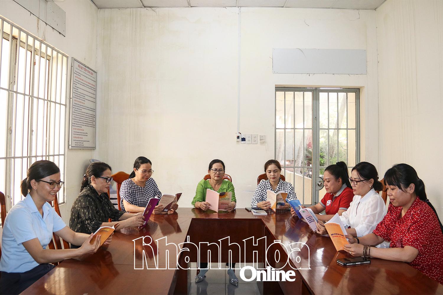 សមាជិក​នៃ​ក្លឹប​ស្ត្រី​ជាមួយ​ច្បាប់​នៅ​ឃុំ Dien Dien អាន​សៀវភៅ និង​សិក្សា​អំពី​ច្បាប់។ 