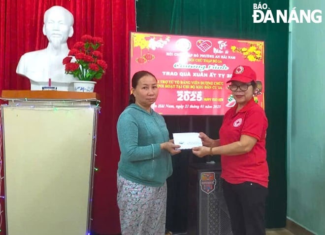 Bà Nguyễn Thị Hồng (bên phải) trao quà cho trường hợp khó khăn tại khu dân cư. Ảnh: THIÊN AN