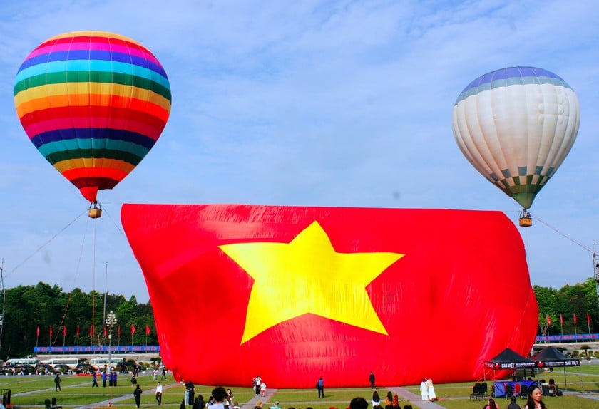 Đại kỳ Tổ quốc đang được 2 chiếc khinh khí cầu kéo lên. Ảnh: Thiên Ý