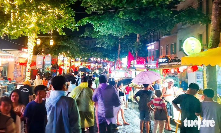 Du khách che dù, mặc áo mưa đi chơi lễ 30-4 ở Phú Quốc - Ảnh 2.