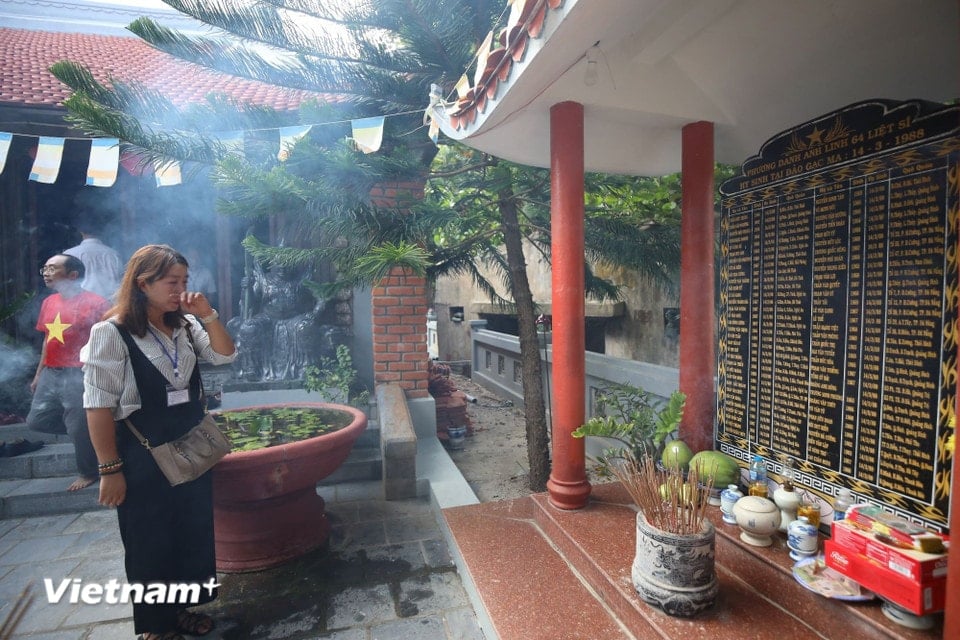 At Sinh Ton Pagoda, Ms. Nguyen Thi Thu Huyen (a Laotian expatriate) could not hold back her tears when reading the names of the soldiers who sacrificed their lives on Gac Ma Island. (Photo: Vietnam+)