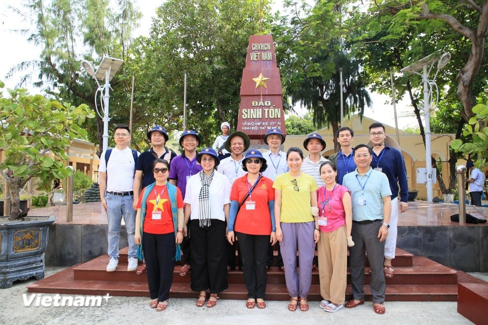 Delegates take photos at the sovereignty marker on Sinh Ton Island. (Photo: Huy Khanh/Vietnam+)