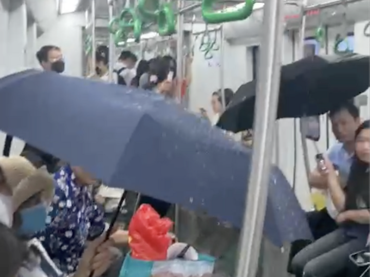 Người dân phải lấy ô che trên chuyến tàu metro Cát Linh - Hà Đông vào chiều 19/5.