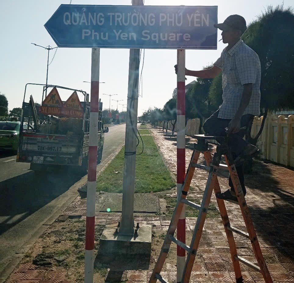 Công nhân hoàn tất việc gắn biển tên và biển chỉ dẫn trên các tuyến đường. Ảnh: MINH DUYÊN