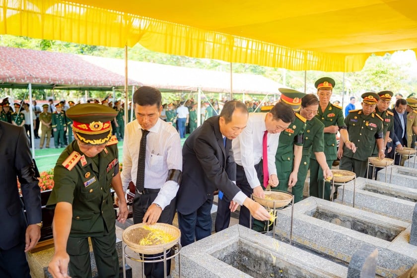 Các lãnh đạo rải hoa và đất xuống phần mộ của từng liệt sĩ.