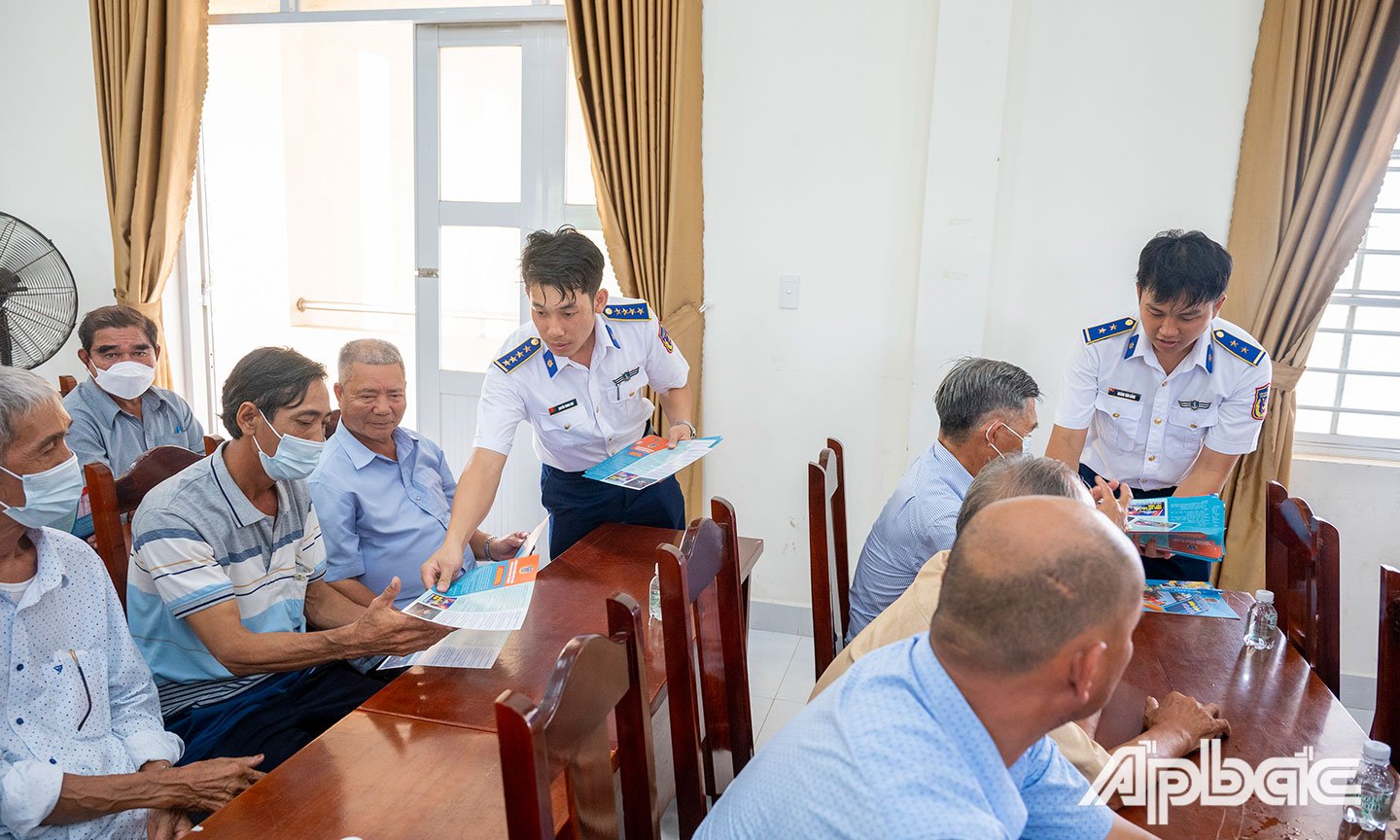 Cán bộ, chiến sĩ Bộ Tư lệnh Vùng Cảnh sát biển 3 phát tờ rơi tuyên truyền cho bà con ngư dân.
