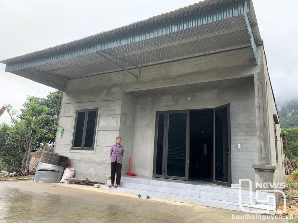 អ្នកស្រី Ngo Thi Can នៅភូមិ Lang Giai ឃុំ La Hien (Vo Nhai) ក្បែរផ្ទះថ្មីរបស់គាត់ដែលត្រូវបានសាងសង់ឡើងដោយមានការជួយជ្រោមជ្រែងពីចលនាលុបបំបាត់ផ្ទះបណ្ដោះអាសន្ន និងទ្រុឌទ្រោម។