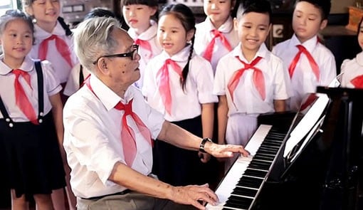 Nhạc sĩ Phong Nhã đang đánh đàn cho các Đội viên Thiếu niên Tiền phong hát. (Ảnh: N.V.Toàn)