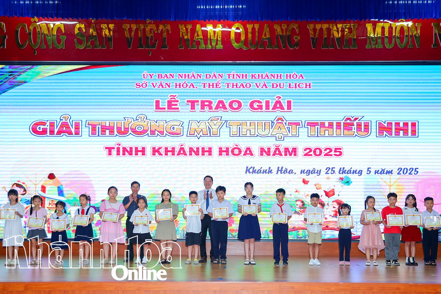 តំណាង​គណៈកម្មការ​រៀបចំ​កម្មវិធី​ប្រគល់​រង្វាន់​មាស​សម្រាប់​ក្រុម​អាយុ​បឋមសិក្សា​ដល់​បេក្ខជន​ដែល​ស្នាដៃ​ទទួល​បាន​រង្វាន់។