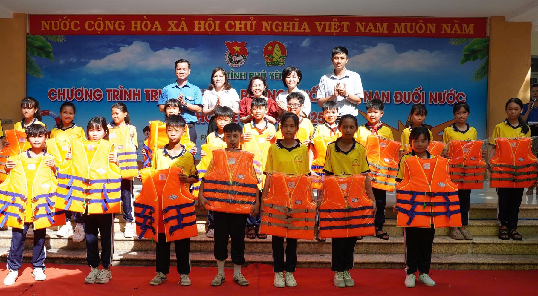 L'Union provinciale de la jeunesse et le Conseil provincial des pionniers ont offert des gilets de sauvetage aux élèves de l'école secondaire Nguyen Huu Tho. Photo : BAO KINH