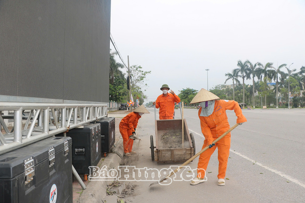Los trabajadores limpian las calles de la procesión de reliquias de Buda en la ciudad de Hung Yen.