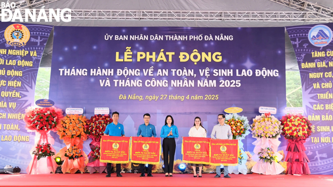 ប្រធានសហព័ន្ធការងារទីក្រុង Phan Thi Thuy Linh (កណ្ដាល) បង្ហាញទង់ត្រានៃសហព័ន្ធការងារវៀតណាមដល់សមូហភាពចំនួន ៤ ដែលមានសមិទ្ធិផលលេចធ្លោក្នុងចលនាត្រាប់តាមសម្រាប់កម្មករល្អ និងកសាងអង្គភាពសហជីពរឹងមាំក្នុងឆ្នាំ ២០២៤។ រូបថត៖ TRA VAN