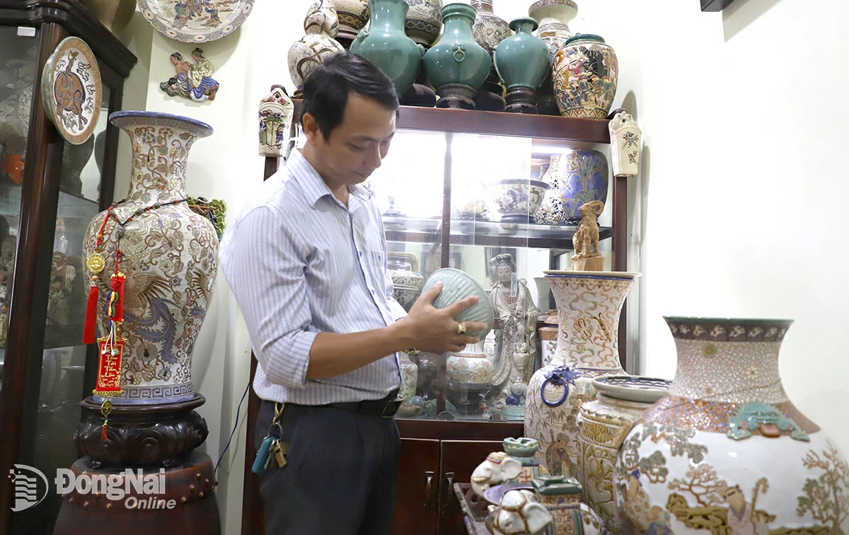 Anh Chu Văn Nam, Chủ nhiệm Câu lạc bộ Di vật, cổ vật Biên Hòa, bên bộ sưu tập gốm cổ lưu giữ, trưng bày tại nhà. Ảnh:L.Na

