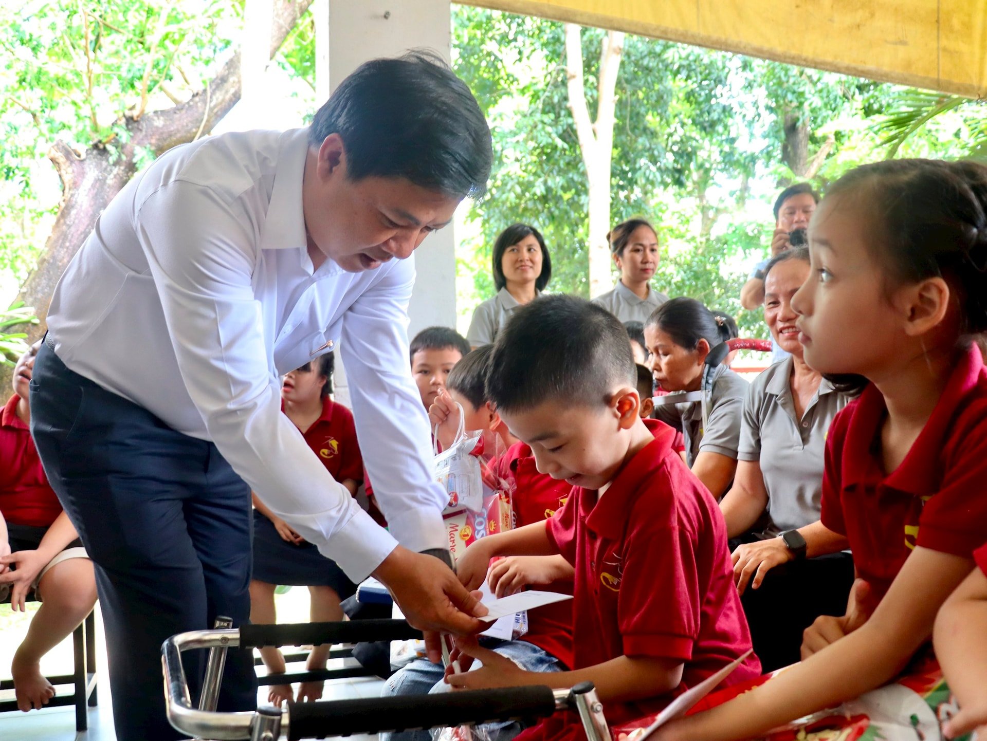 Le secrétaire provincial du Parti, Luong Nguyen Minh Triet, a offert des cadeaux pour encourager les enfants du centre à l'occasion de la Journée internationale de l'enfance. Photo : QUOC TUAN