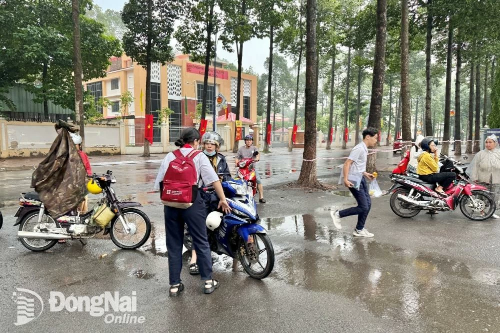 Phụ huynh chở thí sinh hối hả đến hội đồng thi Trường THPT Long Thành (huyện Long Thành). Ảnh: Đăng Tùng