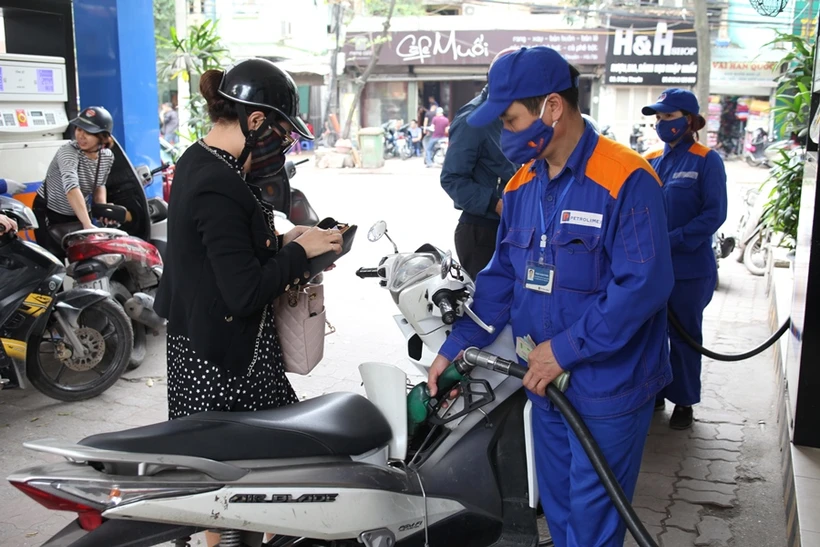 Personal de Petrolimex vende gasolina a clientes. Foto: Vietnam+