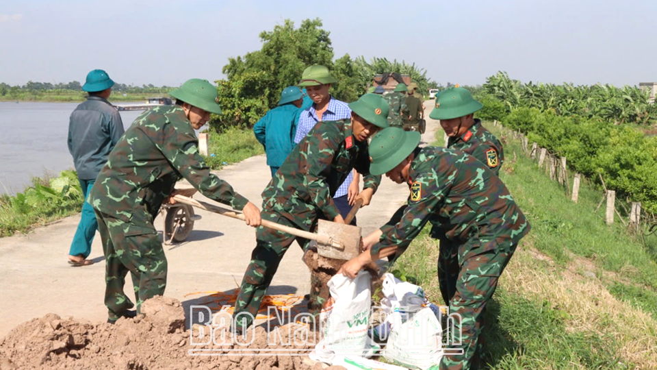 Oficiales, soldados y habitantes del distrito de Vu Ban practican la prevención del desbordamiento del dique en la comuna de Thanh Loi.