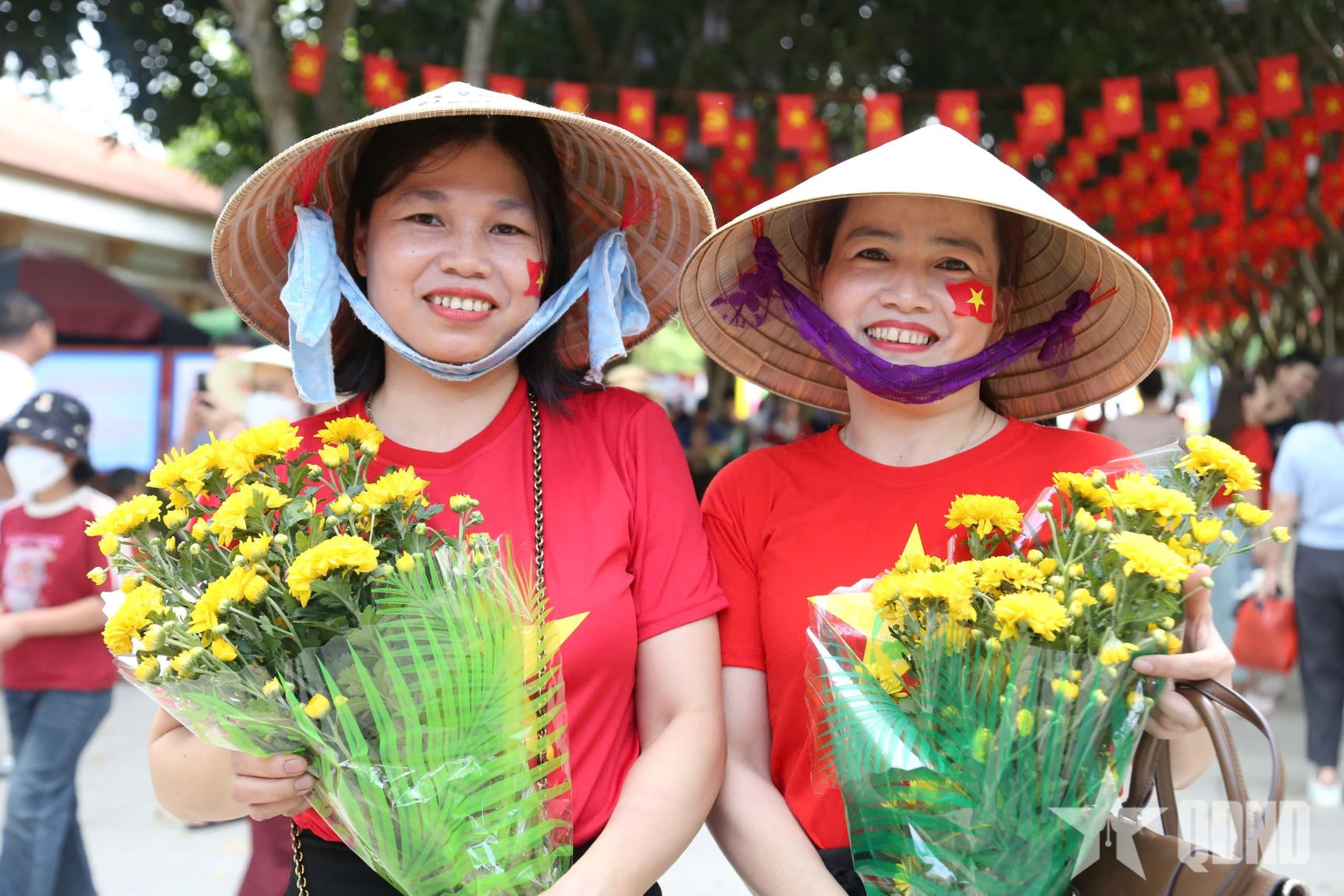 People in red shirts, yellow stars and fresh flowers commemorate Uncle Ho.
