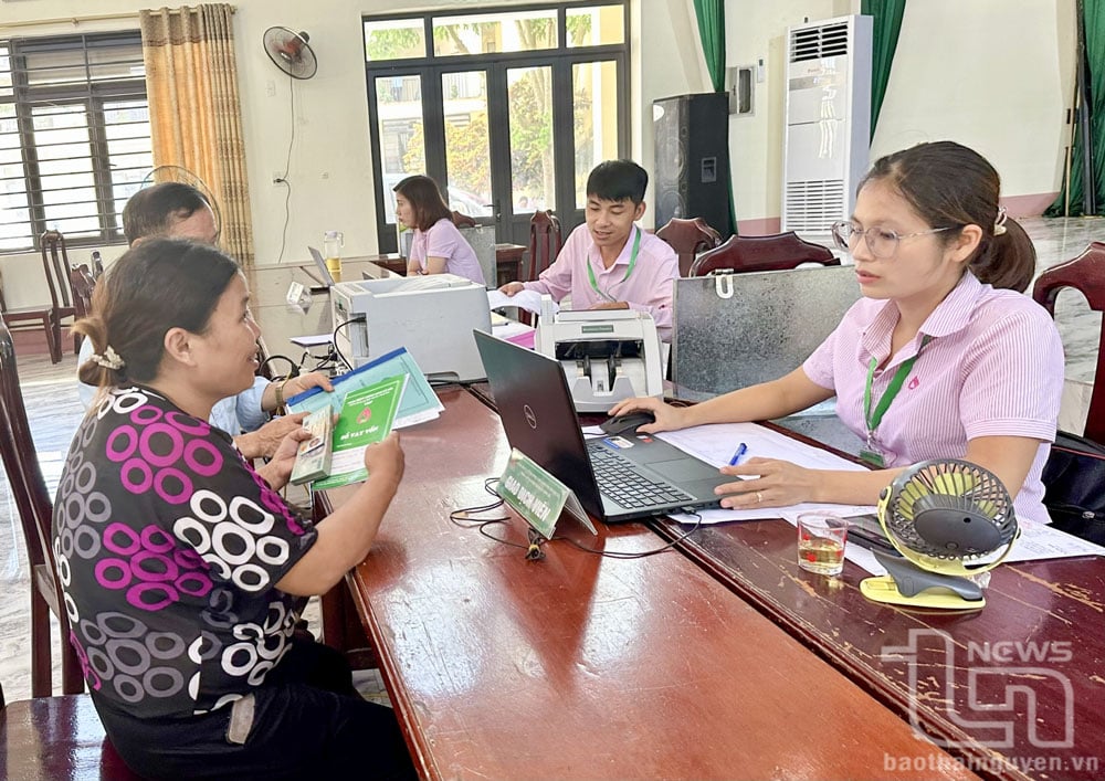Nhân viên Ngân hàng Chính sách xã hội huyện Đồng Hỷ giải ngân vốn chính sách cho người dân xã Tân Long.