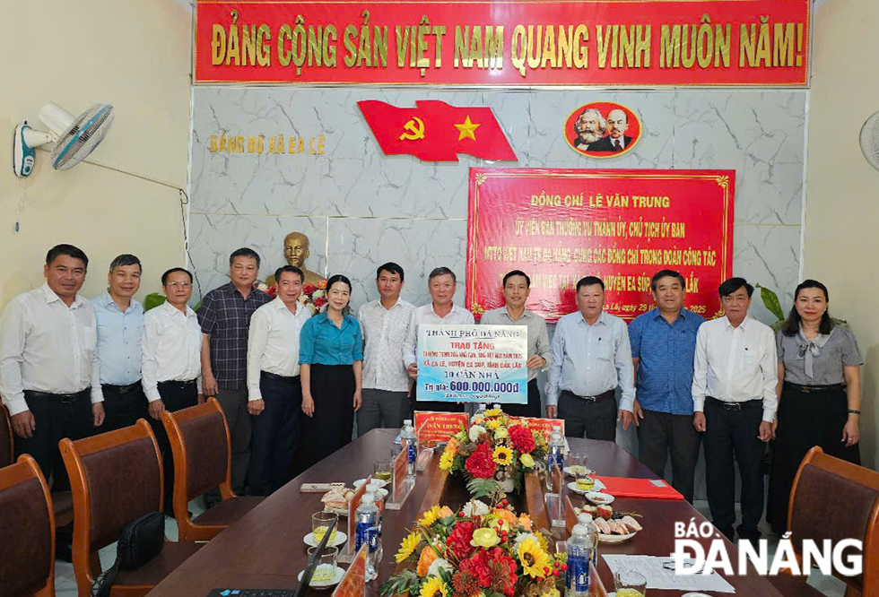 Chủ tịch Uỷ ban MTTQ Việt Nam thành phố Lê Văn Trung (thứ tám, trái sang) trao tặng kinh phí hỗ trợ 10 căn nhà Đại đoàn kết cho người dân xã Ea Lê