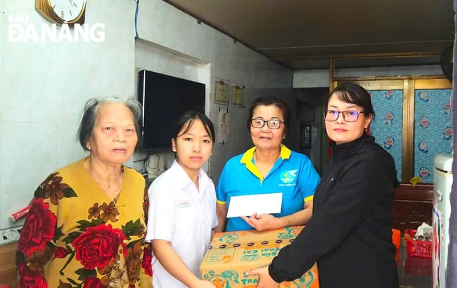 Chị Đặng Thị Cẩm Vân (thứ hai, bên phải sang) nhận đỡ đầu, hỗ trợ kinh phí cho em Nguyễn Thị Nga (thứ hai, bên trái sang) đến khi 18 tuổi. Ảnh: NGỌC QUỐC