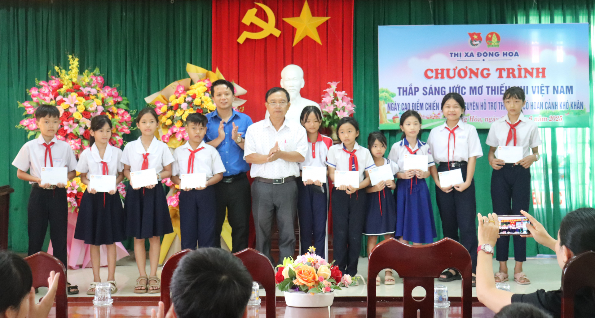El presidente del Comité del Frente de la Patria de la ciudad de Dong Hoa, Nguyen Thanh Than, y el subsecretario de la Unión de Jóvenes de la ciudad, Le Vu Long, otorgaron becas a los estudiantes. Foto: MINH HUYEN