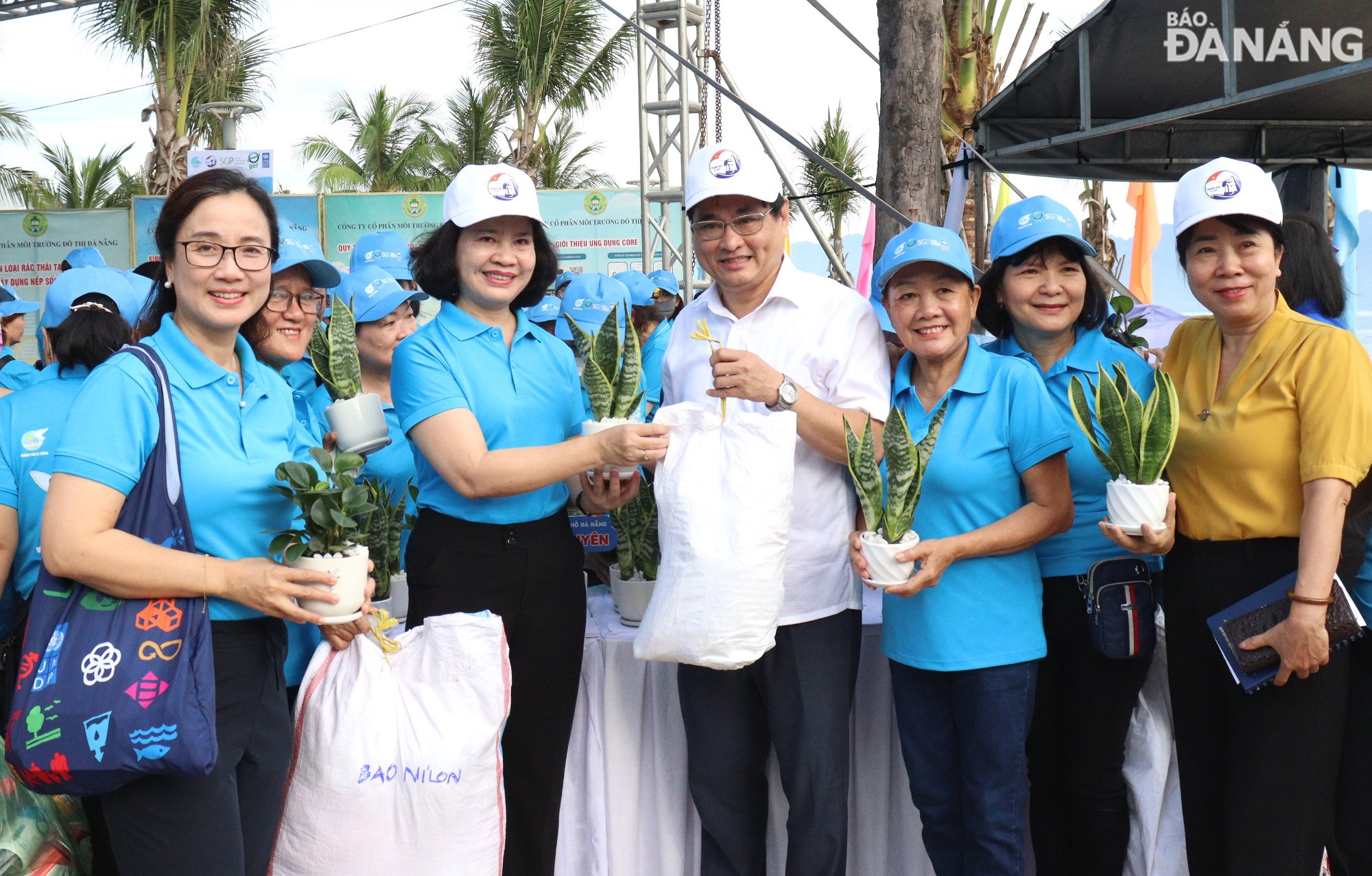 Bí thư Quận ủy Thanh Khê Nguyễn Thành Tiến (thứ 4, từ phải sang), Chủ tịch Hội Liên hiệp Phụ nữ thành phố Đà Nẵng Hoàng Thị Thu Hương (thứ 5, từ phải sang), Điều phối viên quốc gia Chương trình Phát triển Liên Hợp quốc (UNDP) Nguyễn Thị Thu Huyền (bìa trái) tham gia đổi rác thải nhựa, túi ni lông lấy các chậu cây xanh. Ảnh: HOÀNG HIỆP