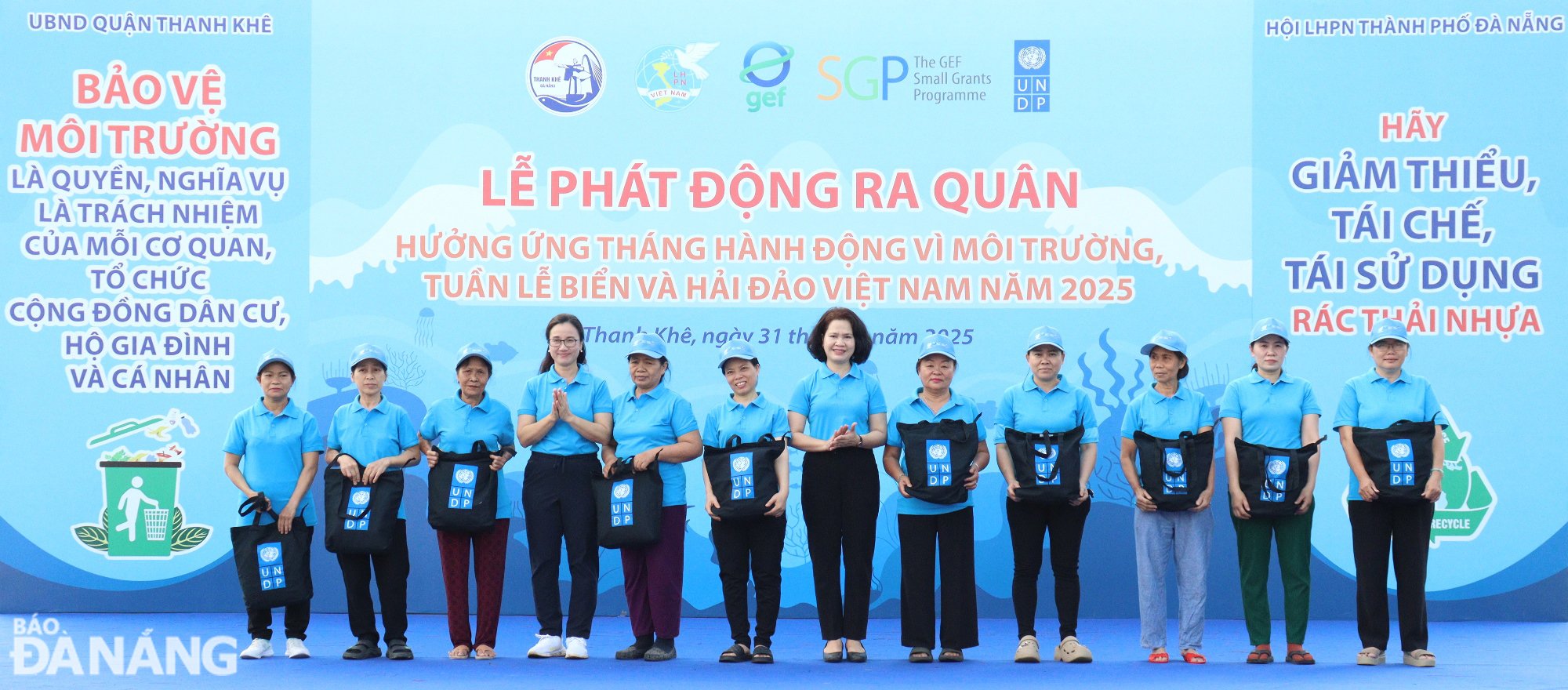 Chủ tịch Hội Liên hiệp Phụ nữ thành phố Đà Nẵng Hoàng Thị Thu Hương (thứ 6, từ phải sang), Điều phối viên quốc gia Chương trình Phát triển Liên Hợp quốc (UNDP) Nguyễn Thị Thu Huyền (thứ 9, từ phải sang) trao tặng dụng cụ, bảo hộ cho phụ nữ thu mua, kinh doanh phế liệu. Ảnh: HOÀNG HIỆP