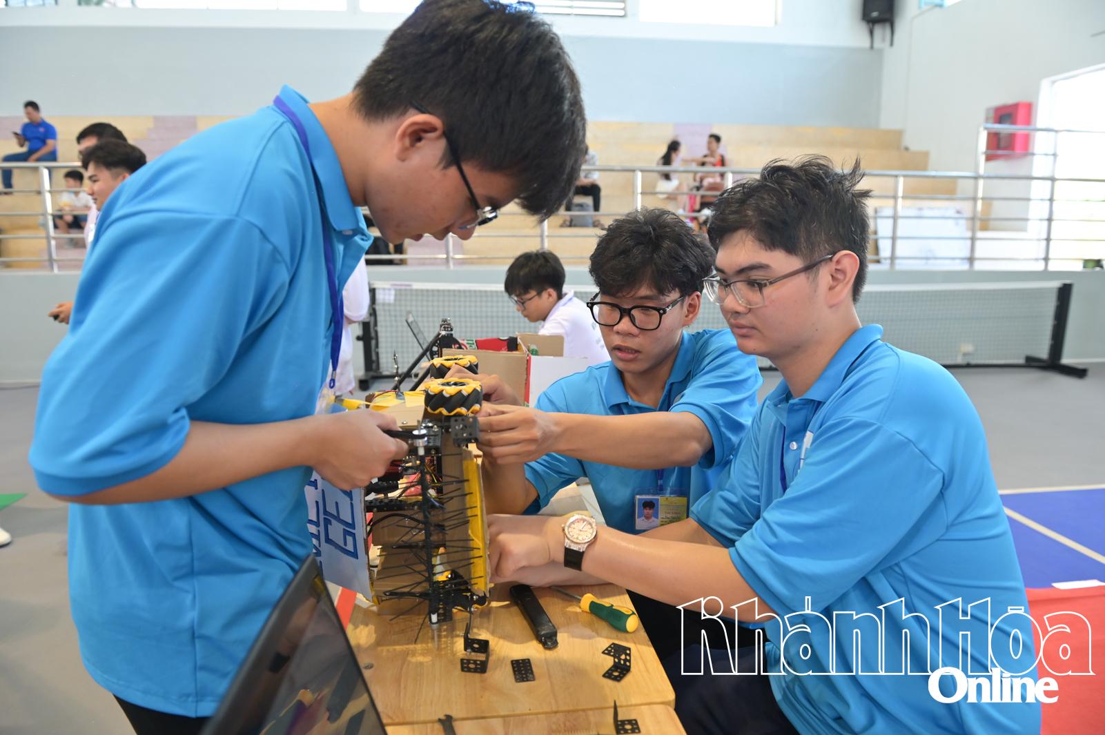 Các đội tinh chỉnh robot trước khi thi đấu.