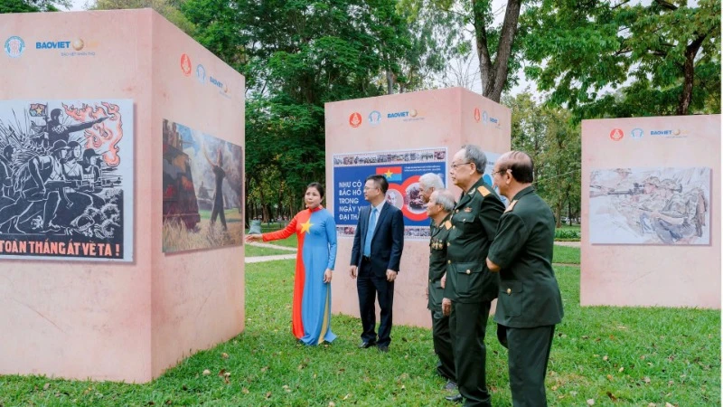 វិចិត្រករ Nguyen Thu Thuy ណែនាំស្នាដៃរបស់នាងដល់អតីតយុទ្ធជនដែលមកទស្សនាការតាំងពិពណ៌។ (រូបថត៖ អាន ហៃ)