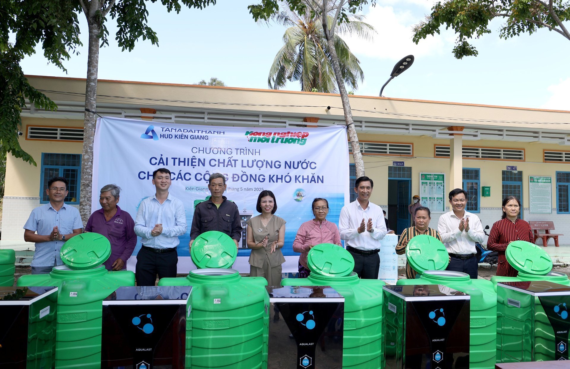 Đại diện Tập đoàn Tân Á Đại Thành trao bồn nước cho bà con. Ảnh: Kiều Trang.