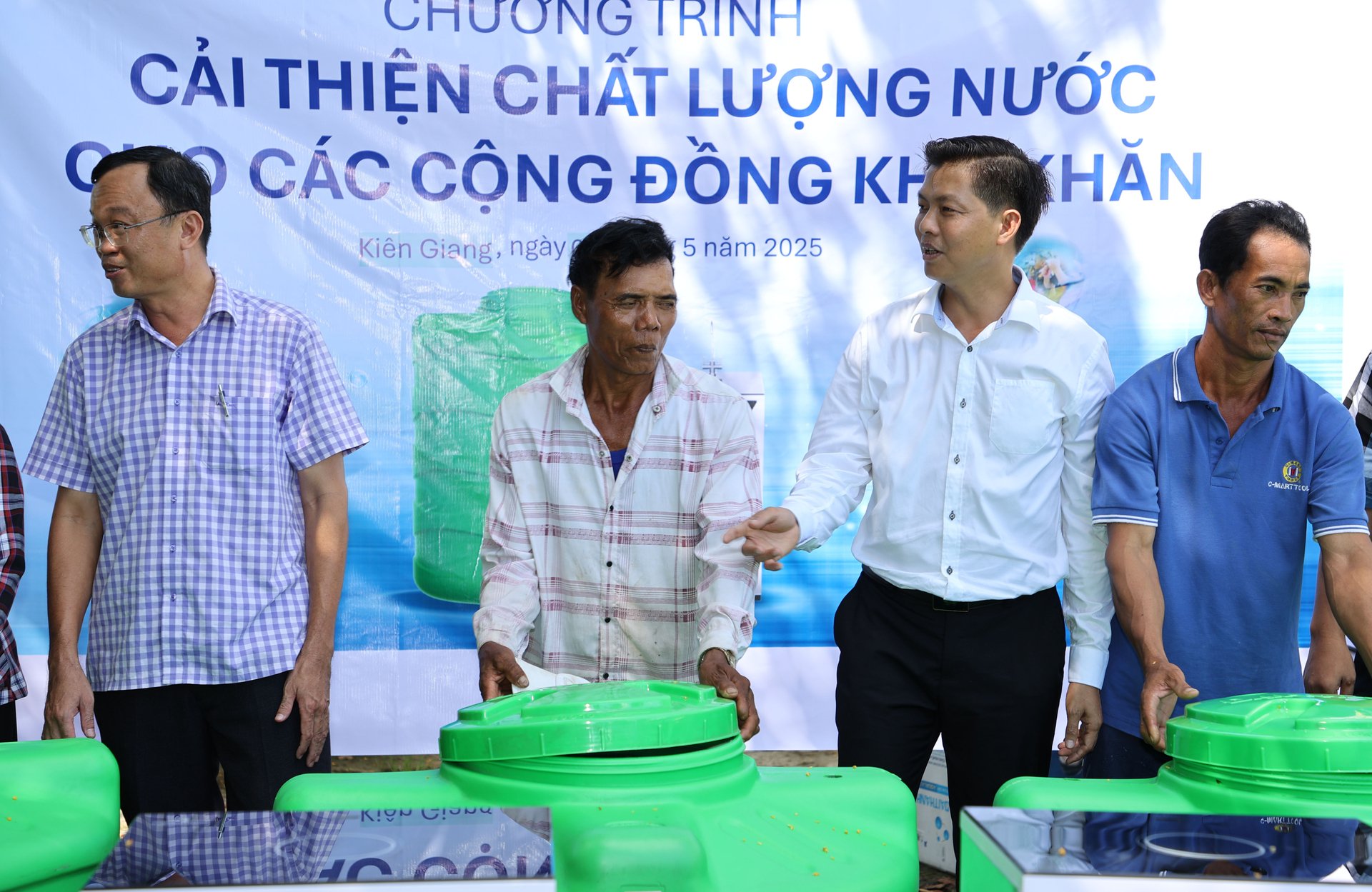 Ông Lê Văn Sơn (thứ hai từ phải qua), Tổng giám đốc Công ty HUD Kiên Giang trao bồn nước cho bà con.