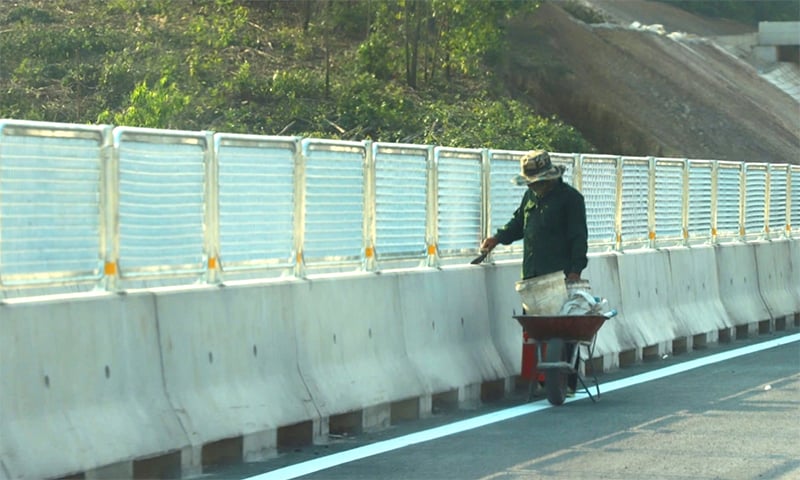 Công nhân quét sơn trên hộ lan, dải phân cách.