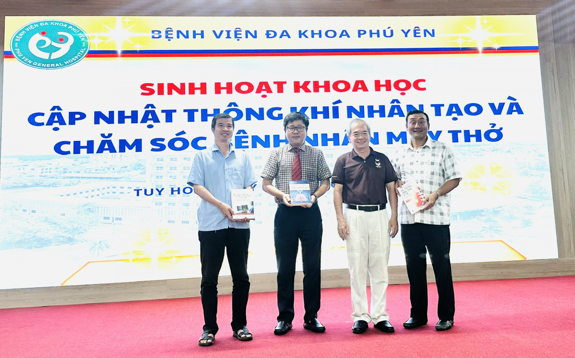 ThS.BS Đặng Thanh Tuấn – Khoa Hồi sức Ngoại, Bệnh viện Nhi Đồng 1, báo cáo viên chính trong chương trình, tặng sách hướng dẫn sử dụng máy thở cho Bệnh viện Đa khoa Phú Yên. Ban giám đốc bệnh viện nhận sách Ảnh: YÊN LAN 
