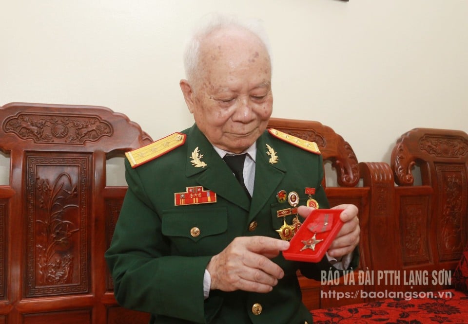 Ông Nguyễn Đức Am bên tấm huân chương được trao vì lập nhiều chiến công xuất sắc trong chiến dịch Điện Biên Phủ