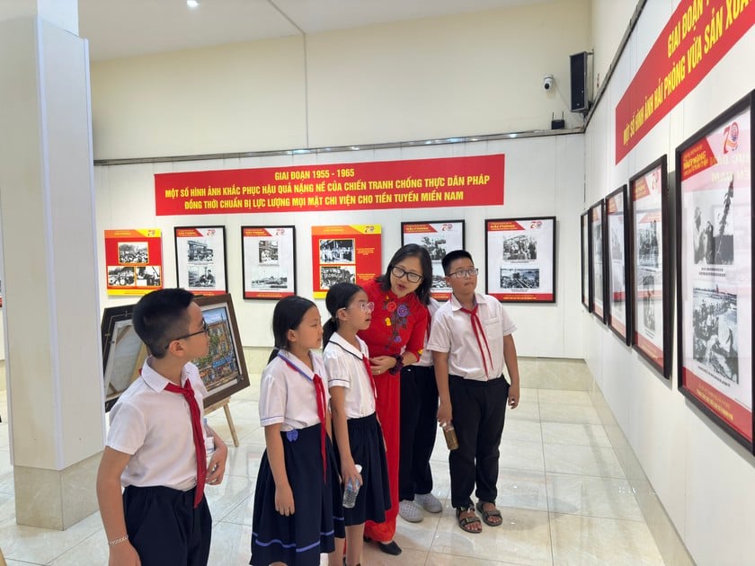 Các em học sinh hào hứng khi được nghe kẻ về cuộc đời, sự nghiệp cách mạng vĩ đại của Chủ tịch Hồ Chí Minh tại triển lãm ảnh