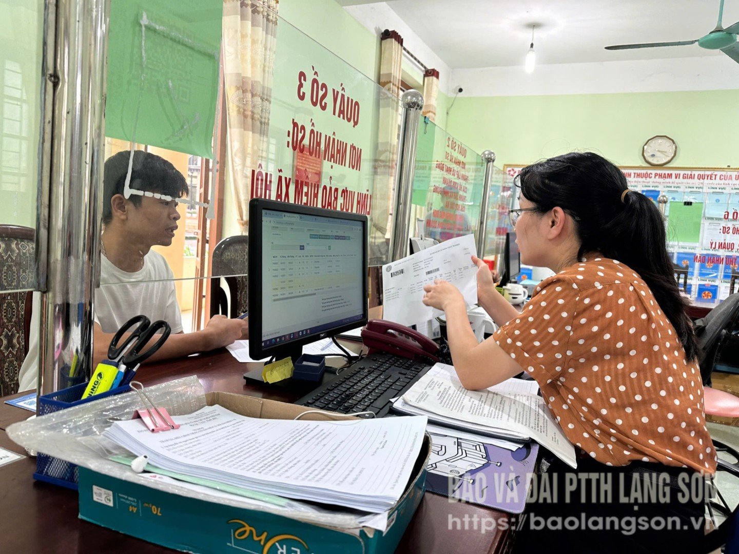 Công chức bộ phận "một cửa" UBND huyện Văn Quan hướng dẫn người dân điền thông tin khi đến thực hiện thủ tục hành chính