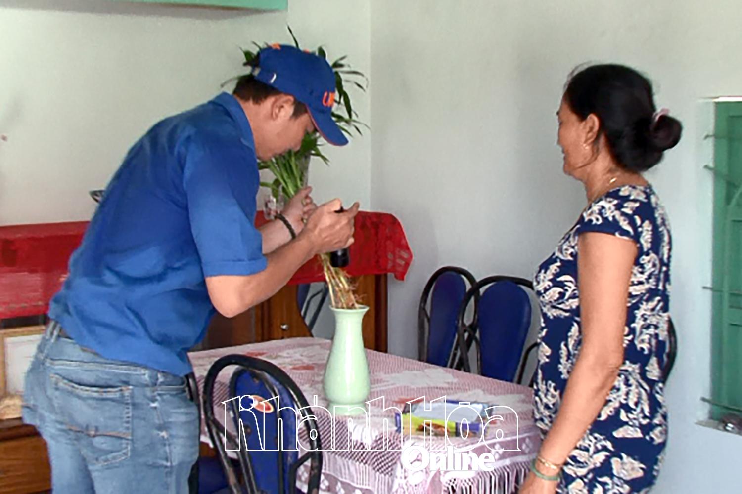 Cán bộ y tế Trung tâm Kiểm soát bệnh tật tỉnh kiểm tra lăng quăng trong bình hoa tại hộ dân ở huyện Cam Lâm.