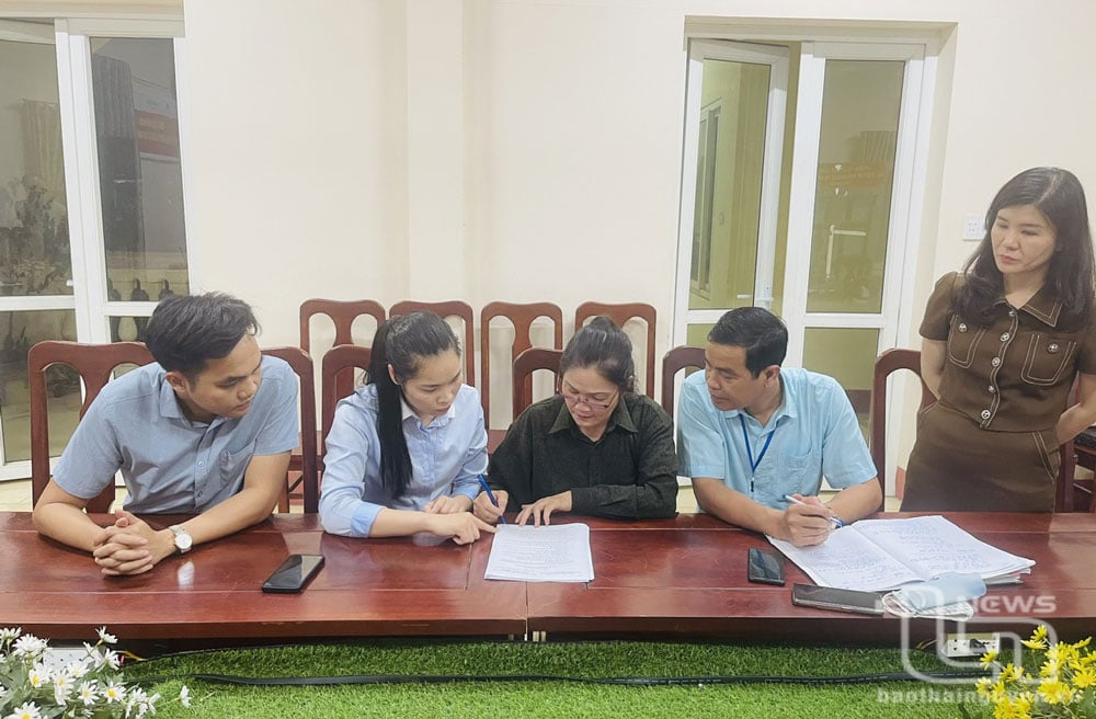 Bà Hoàng Thị Biên (áo đen), chủ tài khoản “Hỏa Diệm Sơn”, ký biên bản vi phạm thông tin sai sự thật về Chương trình xóa nhà tạm, nhà dột nát trên địa bàn thị trấn Đu, huyện Phú Lương.