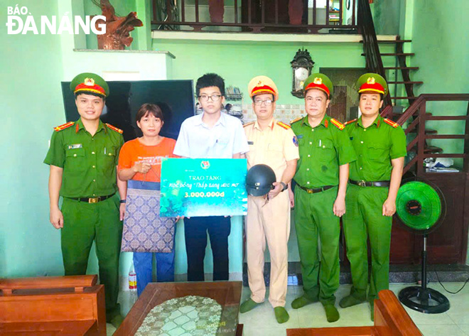 Thực hiện mô hình “Thắp sáng ước mơ”, Thượng úy Lê Hoàng Vũ (bên trái) hỗ trợ học bổng em Trần Anh Kiệt (thứ ba, bên trái sang) học sinh lớp 8 trường THCS Đặng Thai Mai, đến khi em đủ 18 tuổi. Ảnh: P.V