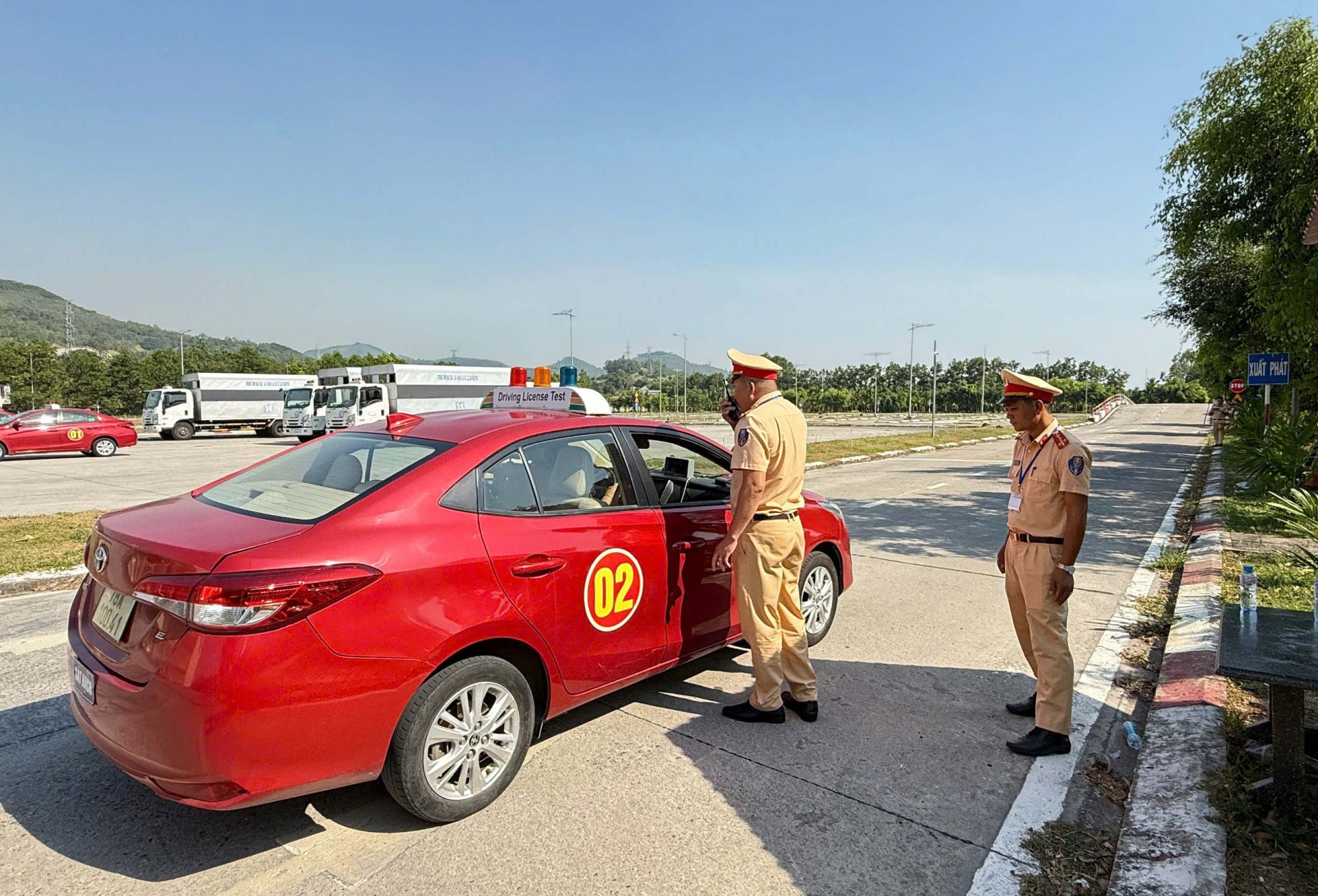 Các kiểm soát viên thuộc Phòng Cảnh sát giao thông kiểm tra thông tin học viên trước khi vào phần thi sát hạch thực hành lái xe trong hình. Ảnh: NGÔ XUÂN