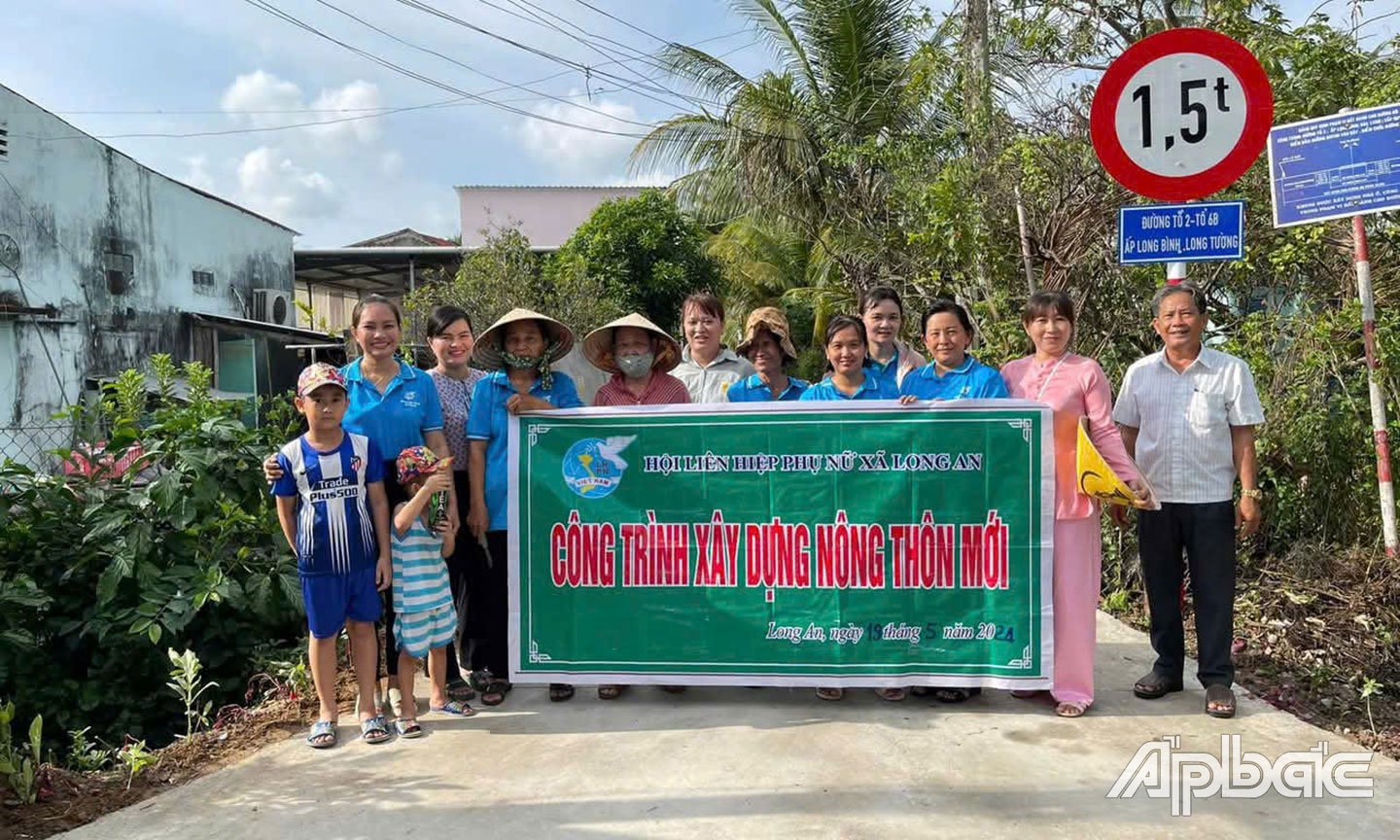 Cán bộ, hội viên phụ nữ xã Long An trồng, chăm sóc tuyến đường hoa góp phần xây dựng cảnh quan môi trường xanh - sạch - đẹp.