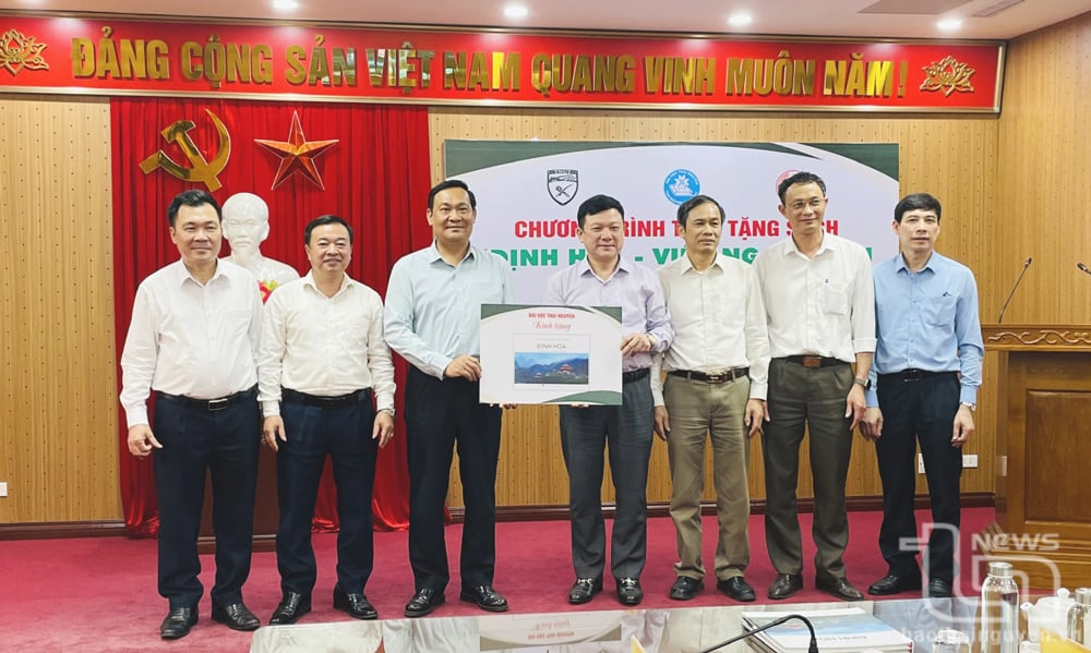 Lãnh đạo Đại học Thái Nguyên trao tặng tượng trưng 1.000 cuốn sách Định Hóa - Viên ngọc xanh của Thái Nguyên cho lãnh đạo huyện.