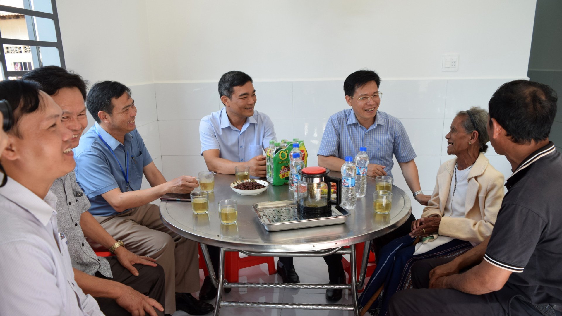 Lãnh đạo huyện, xã trò chuyện, thăm hỏi và KWệ năm nay đã 80 tuổi, trong căn nhà mới vừa được trao tặng