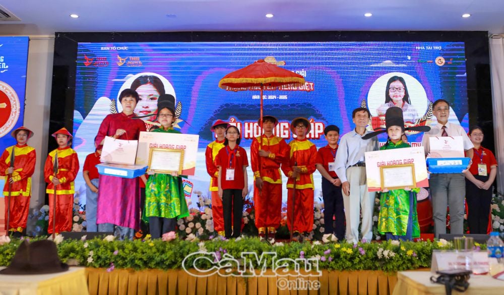 Cô trò nhỏ Bảo Tiên (bên phải) đón nhận giải Hoàng Giáp, một trong các danh hiệu vinh danh thí sinh xuất sắc nhất tại vòng Ðình, cấp Quốc gia, sau danh hiệu Trạng Nguyên (giải cao nhất) và xếp cùng với các danh hiệu khác như Bảng Nhãn, Thám Hoa.                                                                                                                                                                                         (Ảnh nhà trường cung cấp)