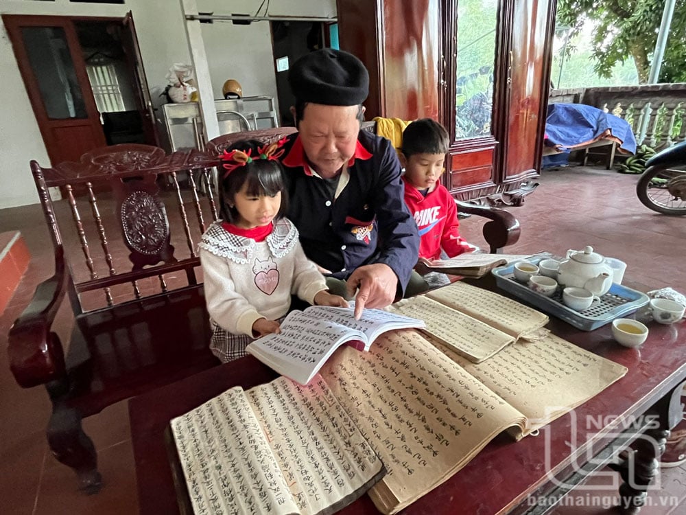 Nghệ nhân ưu tú Bàn Đức Báo, thị trấn Quân Chu, dạy chữ Dao cho các cháu nhỏ.