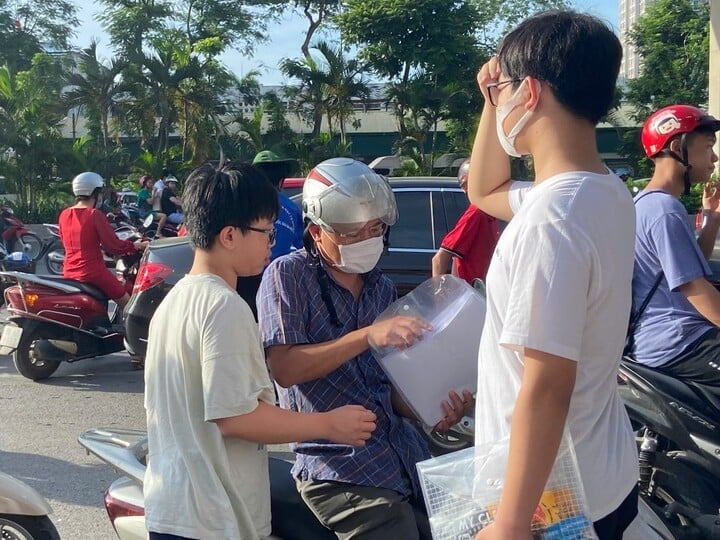 Candidates have their documents checked by their parents before entering the exam room. (Photo: Kim Anh)