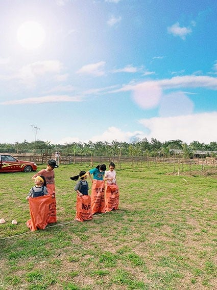 Cả gia đình cùng chơi trò chơi nhảy bao bố. (Ảnh: Happy Farm)