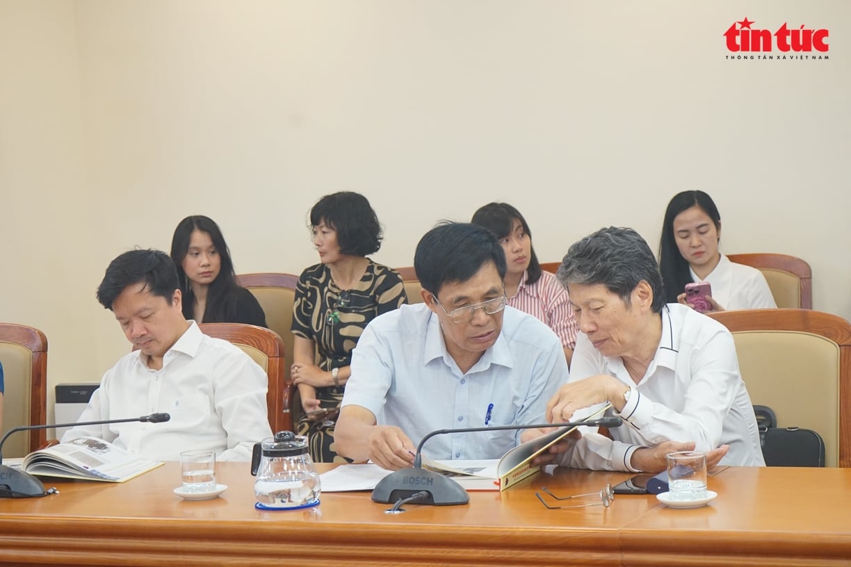 Đại biểu chăm chú xem cuốn sách ảnh với nhiều tư liệu quý giá về hành trình 100 năm báo chí cách mạng Việt Nam.