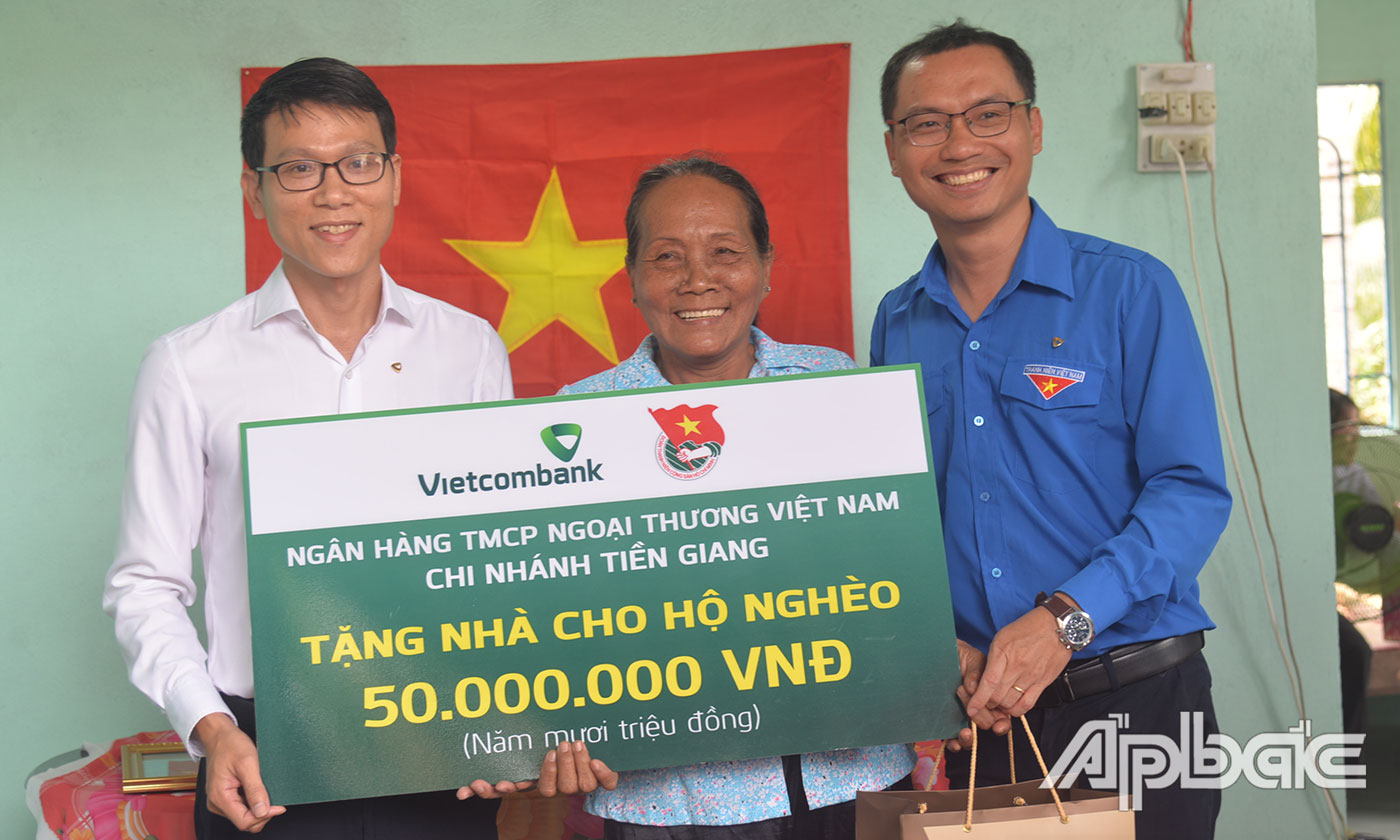Đại diện Vietcombank Tiền Giang trao bảng tượng trưng hỗ trợ kinh phí xây nhà.